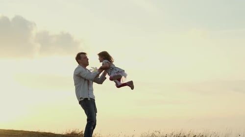 Familienurlaub in der Natur. Papa dreht seine Tochter in seinen Armen, als würde sie fliegen.