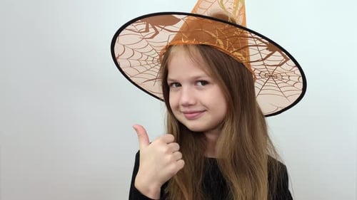 Girl Dressed as Witch Smiles and Gives Thumbs Up