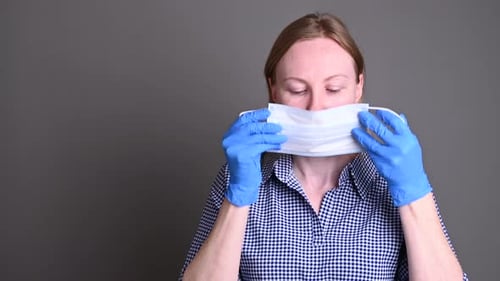 Woman Wearing Gloves Puts on Medical Mask