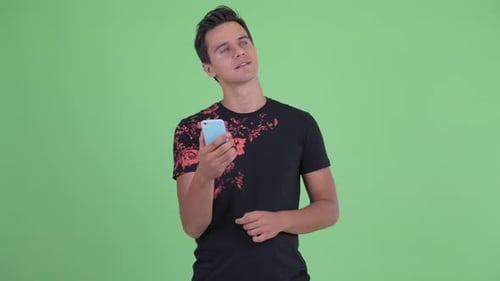 Man Using Cellphone and Smiling Against Green Screen