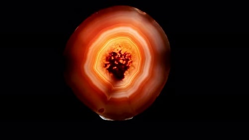 El
ágata brasileña retroiluminada mostraba densas capas de anillos multicolores. Muestra mineral.