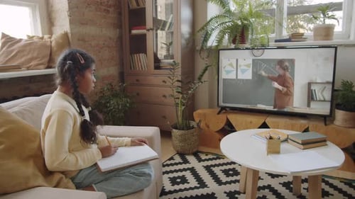 Afro-American Girl Watching Online School Lesson and Studying at Home