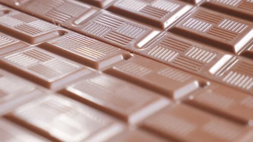 Tasty chocholate blocks in a row fine glazed texture 4K 3840X2160 30fps UltraHD video - Slow tilt ov