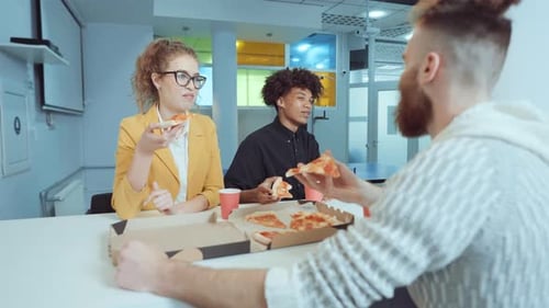 Colleagues Eating Pizza Together in Office Break Room
