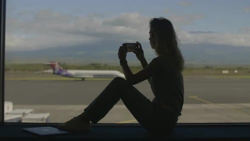 Woman at Airport Taking Pictures with Phone