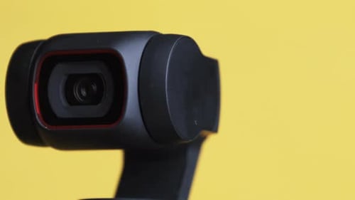 Camera Rotating on Yellow Background