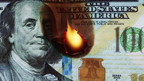 Brennende amerikanische Hundert-Dollar-Banknote auf schwarzem Hintergrund