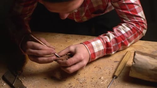 View From Above of Wood Master Working in Craft Studio Alone and Carving Patterns on Small Wooden