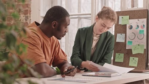 Colleagues Doing Paperwork Together in Office