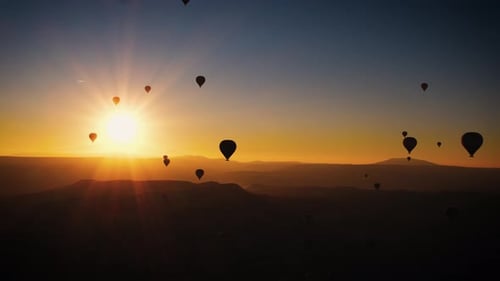 Hot Air Balloons Soaring Over Mountain at Sunrise