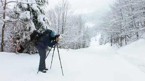 The Photographer Shoot a Mountain Forest in the Carpathians in Rainy and Snowy Weather
