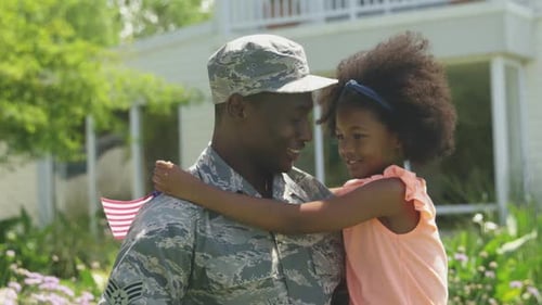 Military Father and Child Embrace with American Flag