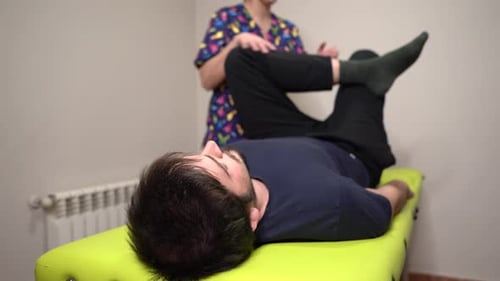 Physiotherapist Finishing Leg Stretch Exercise With Patient