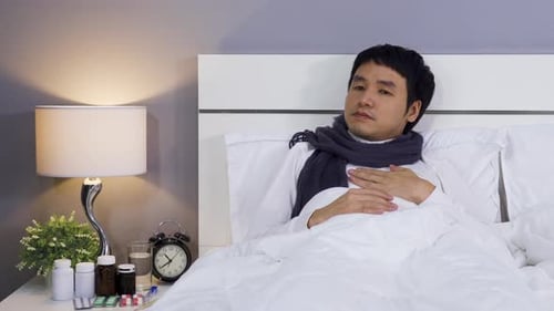 Sick Adult Lying in Bed with Cold and Flu