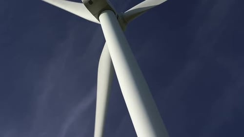 Blades of a Large Wind Turbine in a Field Against a Background of Cloudy Grey Sky