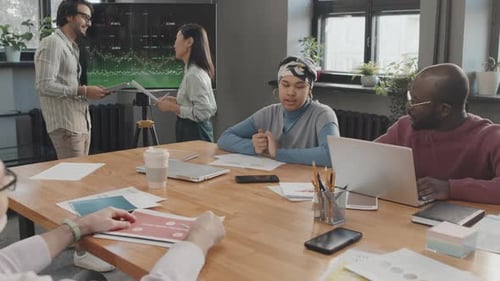 Team Meeting with Data Presentation in Modern Office