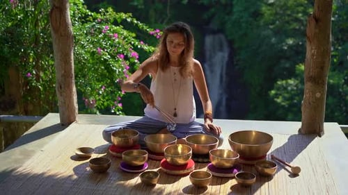 Woman Plays Singing Bowls in Tropical Setting