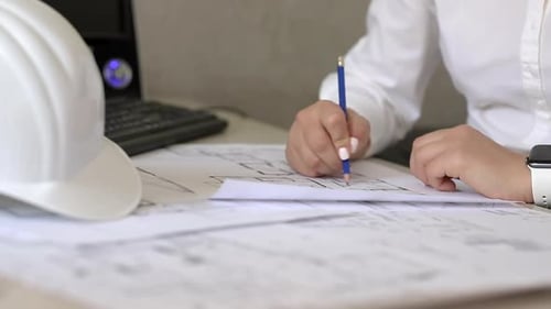 Bauingenieur macht sich Notizen zu Papierplänen