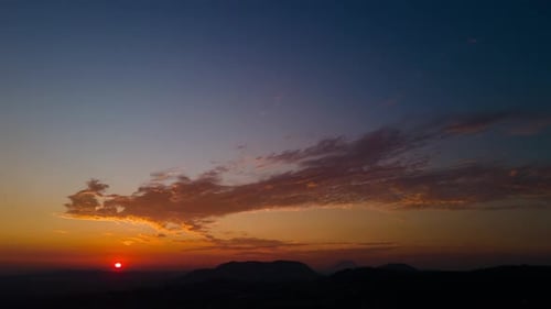 Dramatic Sunrise Over Dark Mountain Range from Above