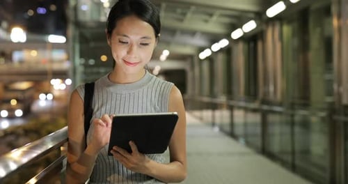 Young Woman Using Tablet at Night in the City