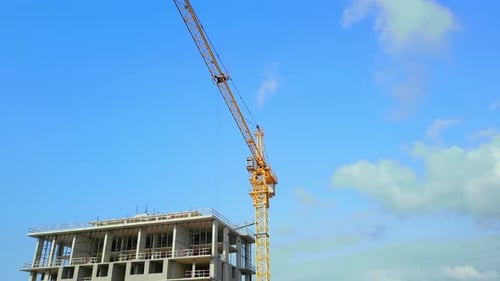 Grue de construction par Drone sur chantier avec bâtiment construit