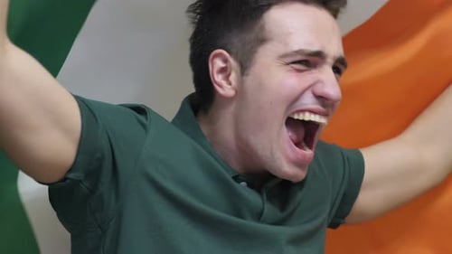 Young Man Cheering with Ireland Flag Raised