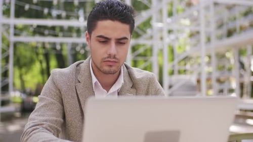 Young Adult Working on Laptop at Cafe