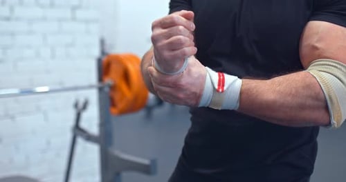 Athlete Corrects the Elastic Bandages on the Wrists and Muscles of the Hands