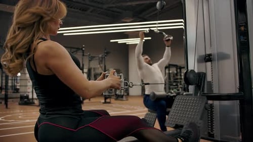 Woman Using Seated Row Machine at Gym