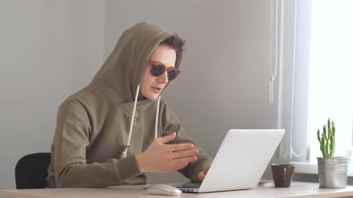 Junger Hacker konzentriert sich auf Codierung, Hacker schaut auf Screen Monitoring Stock Online