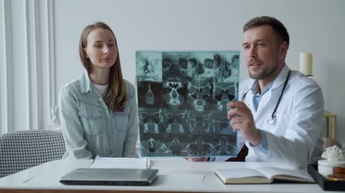 Man Doctor Show Xray Result and Explain of Health Problem to Women Patient in His Office