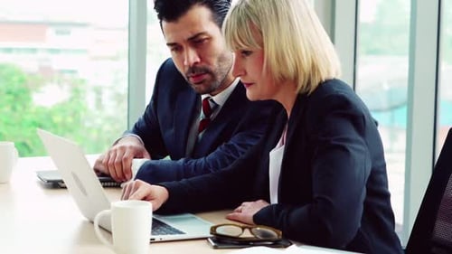 Two Business People Talk Project Strategy at Office
