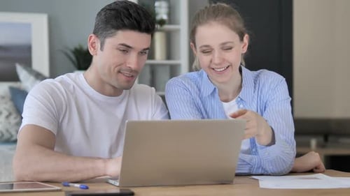 Man and Woman Working on Laptop Together