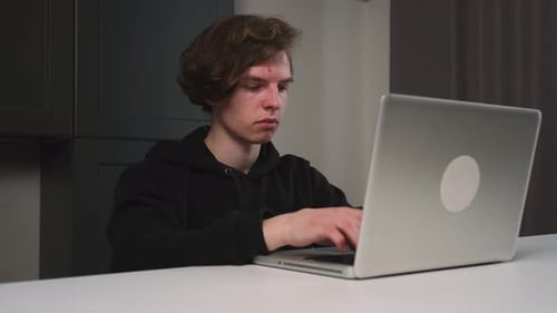 Porträt eines gutaussehenden Mannes, der auf Laptop tippt und im Home-Office arbeitet
