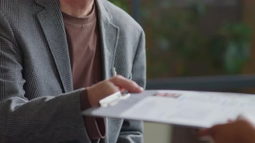 Homme d'affaires senior donnant un CV au responsable des ressources humaines lors d'un entretien
