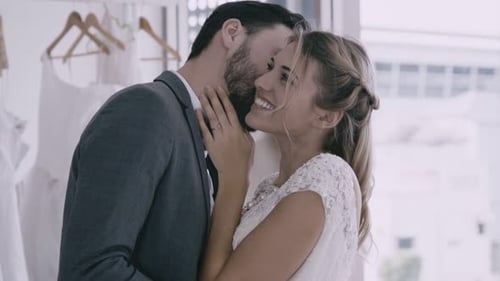 Happy Couple Share Loving Kiss in Bridal Boutique
