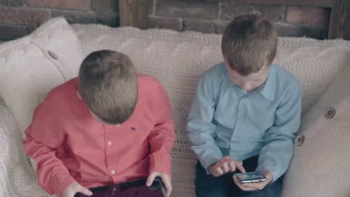 Boys Using Phone and Tablet on Couch