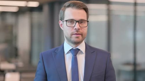 Man in Suit Talks to Camera in Office