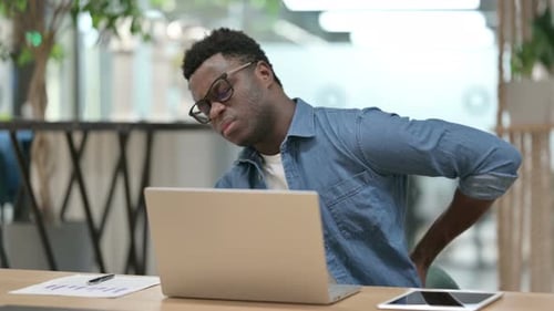 Young Adult Experiencing Back Pain at Work