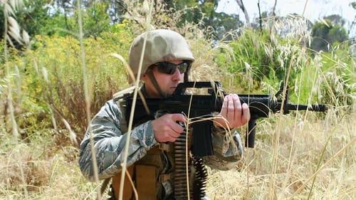 Soldier Aims Rifle in Camouflage Gear Outdoors