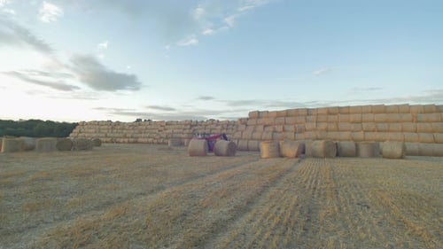 Hay Bales in a Rural Field with Tractor