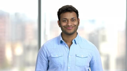 Man Smiles Serenely Indoors in Simple Portrait