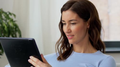 Smiling Woman Using Tablet Indoors