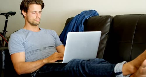 Man Lying on Couch Using Laptop Computer