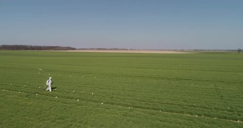 Agricultural Researcher Spraying Filed with Herbicides or Pesticides