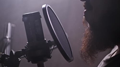 Un homme lit un texte dans un studio d'enregistrement