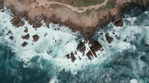 White Waves Are Crashing Over Sharp Cliffs, Scenic Top Down View on Coastline