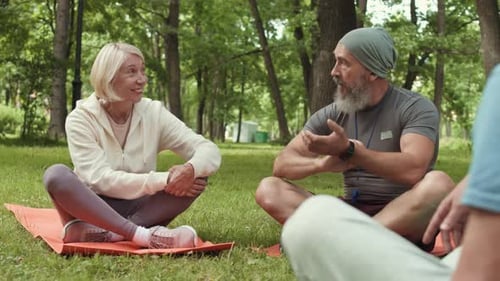 Adults Exercising and Talking in Green Park