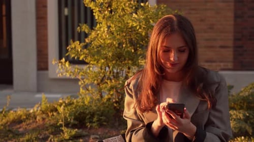 Young Woman Using Smartphone at Golden Hour