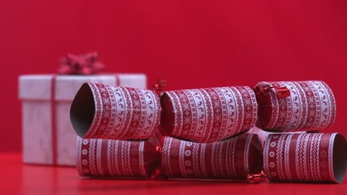 Christmas crackers falling and bouncing beside present